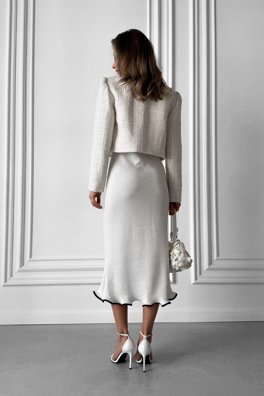 Knitted white midi dress without sleeves, with a wave at the bottom