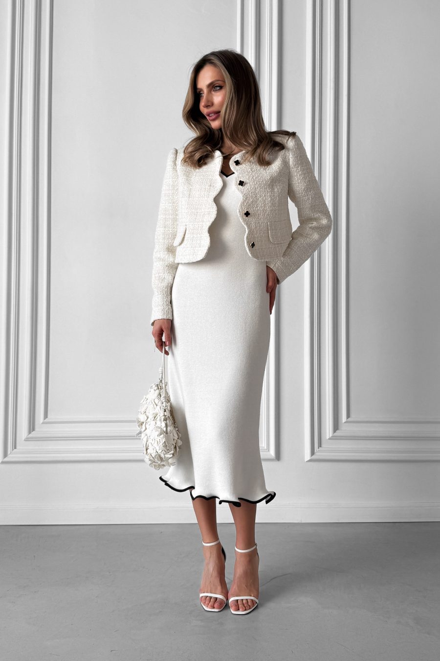 Knitted white midi dress without sleeves, with a wave at the bottom