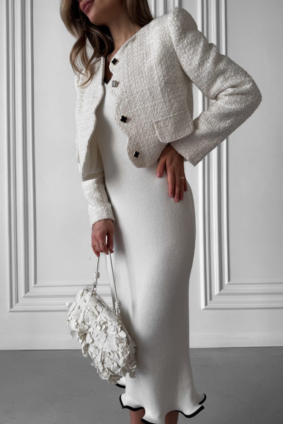 Knitted white midi dress without sleeves, with a wave at the bottom