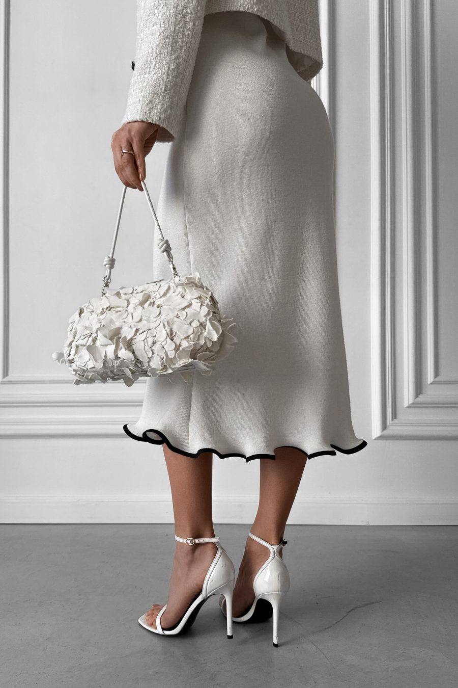 Knitted white midi dress without sleeves, with a wave at the bottom