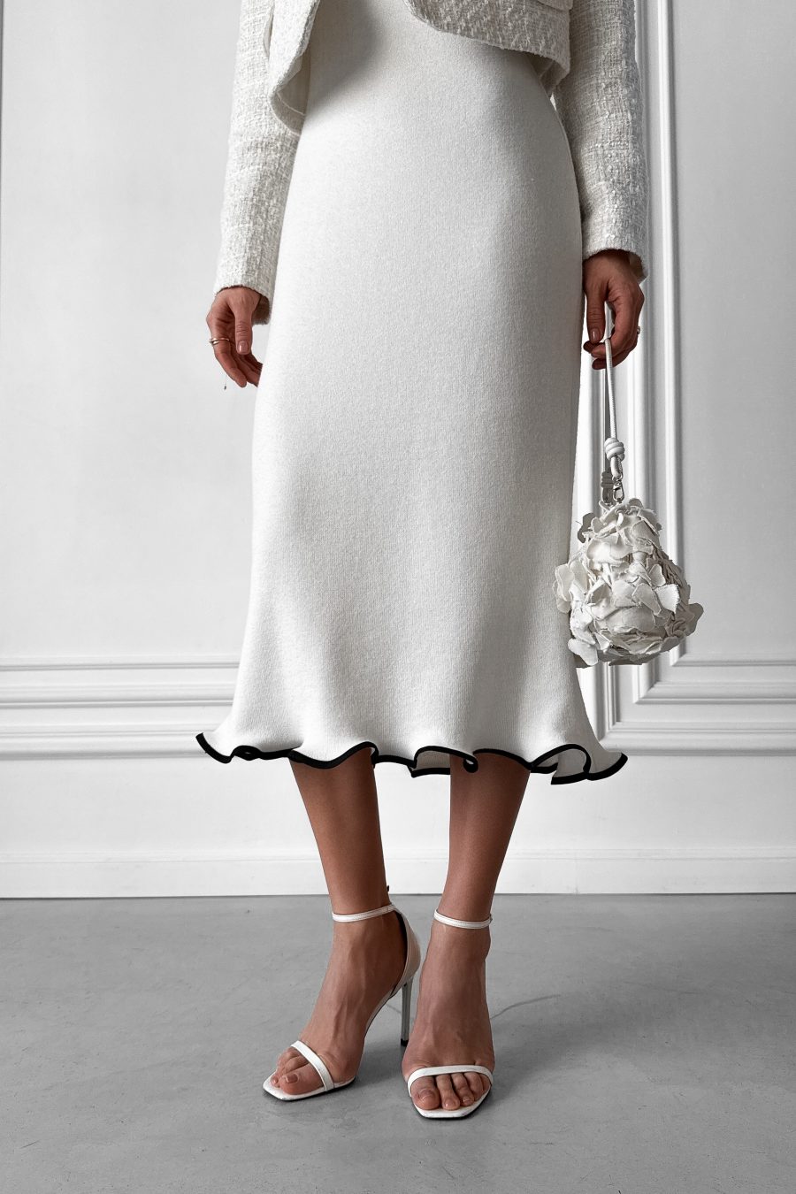 Knitted white midi dress without sleeves, with a wave at the bottom